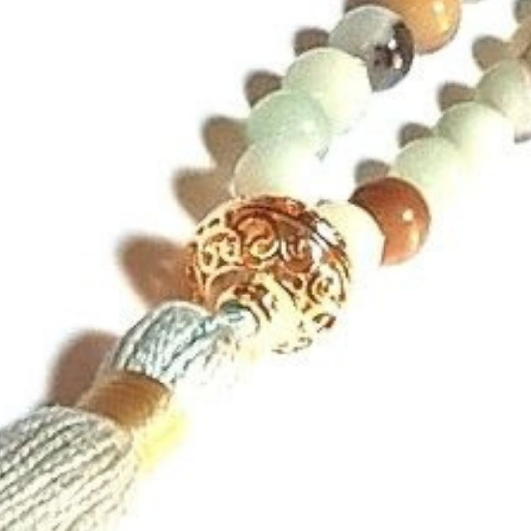 Close up of handmade Amazonite and Rudraksha Arogita Mala necklace with gold filigree guru bead