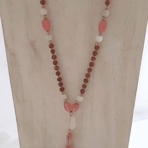 Close up of handmade Tourmalinated Quartz, Rudraksha, Rose Quartz and Amazonite Mala necklace Rose Quartz guru bead on jewellery bust