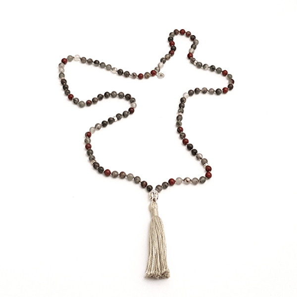 Handmade Bloodstone Empowering necklace mala with Buddha head guru bead laid loosely on table