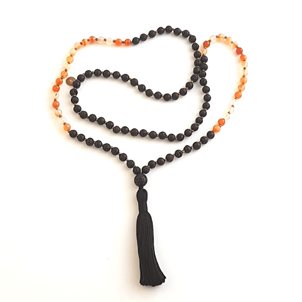 Handmade Lava and Carnelian Creativity Mala necklace loosely laid out on table