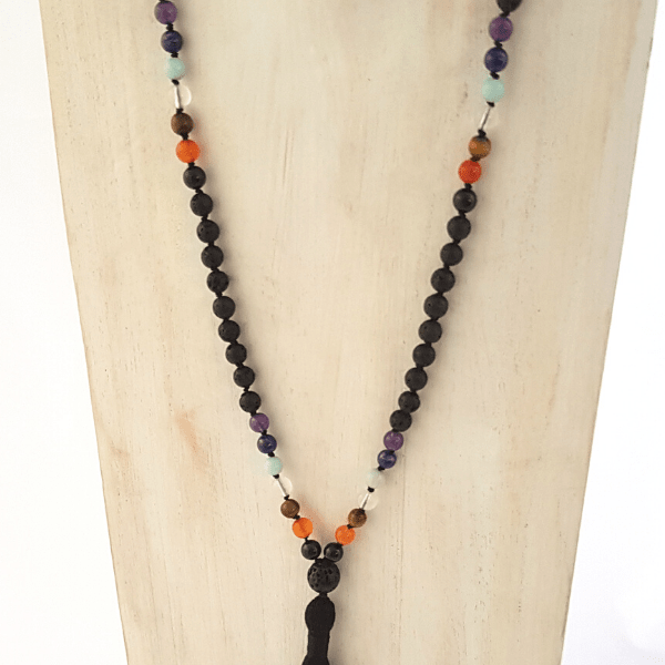 Close up of handmade lava and seven crystal chakra balancing mala necklace on jewellery bust