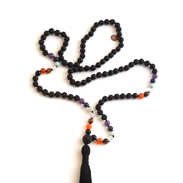 Handmade lava and seven crystal chakra balancing mala necklace laid loosely on table