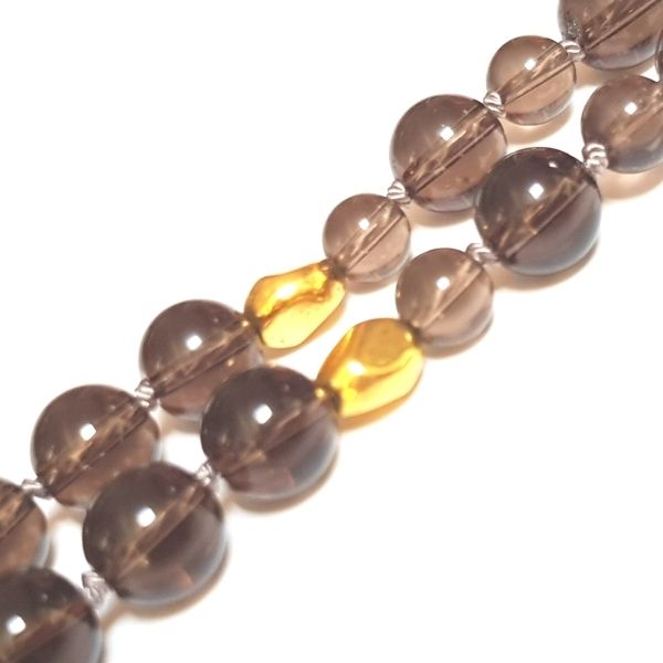 Close up of gold plated spacer and Smokey Quartz beads in handmade Smokey Quartz Root Chakra mala necklace