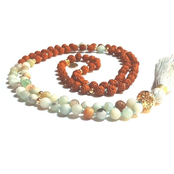 Handmade Arogitā Mala Necklace – Health, Happiness & Emotional Balance with gold filigree guru bead curled on table