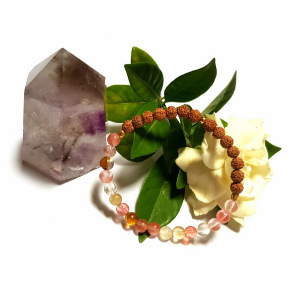 Handmade Harmonising Bracelet – Tourmalinated Quartz & Rudraksha for Peace on white background with Gardenia Flower and Amethyst Crystal Tower