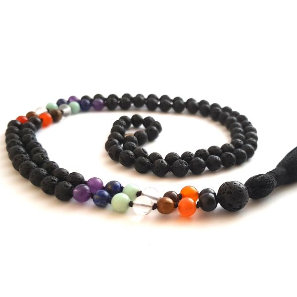 Handmade lava and seven crystal chakra balancing mala necklace curled on table