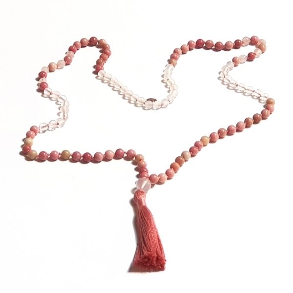 Handmade Rhodochrosite and Rose Quartz Heart Chakra Mala necklace laid loosely on table