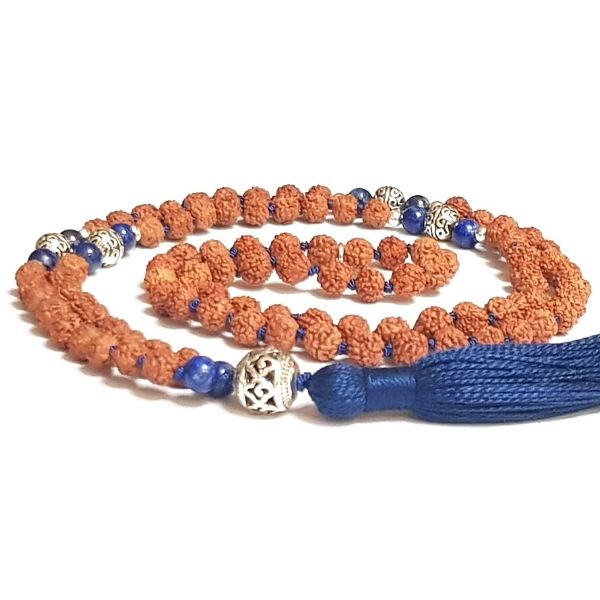 Handamde Rudraksha and Lapis Lazuli Insight Mala necklace with silver filigree guru bead curled on a table