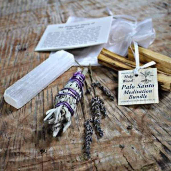 Palo Santo bundle with selenite, sage smudge and lavender sprigs on wooden table