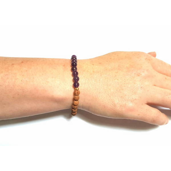 Woman wearing Handmade Recalibrate Bracelet – Amethyst & Rudraksha Crown Chakra Bracelet with white gardenia flower